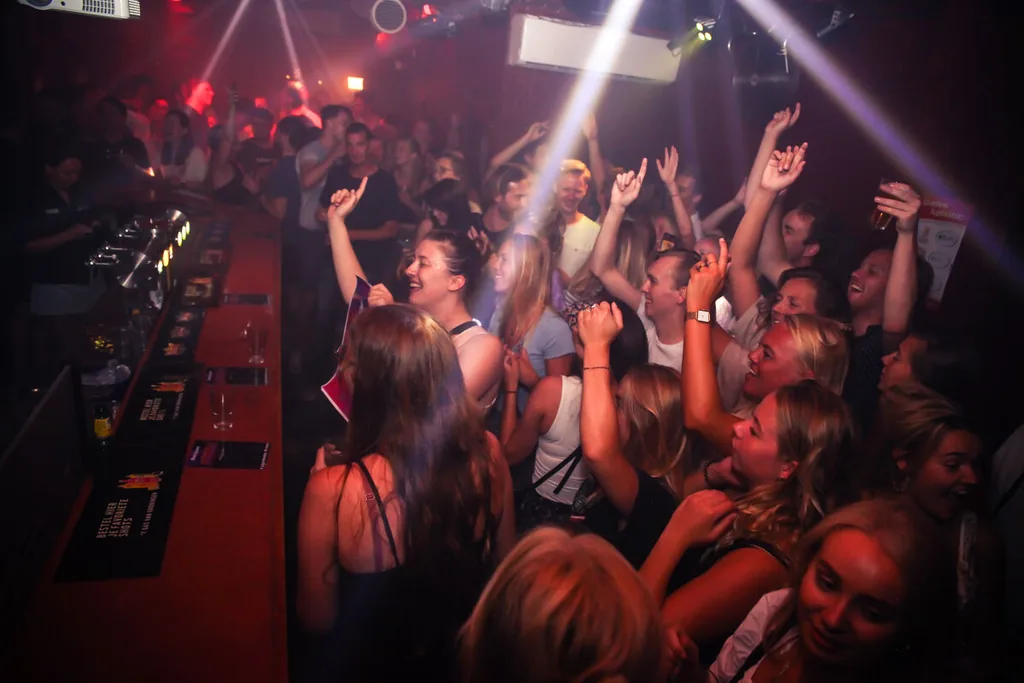 Feestend publiek in rood barlicht
