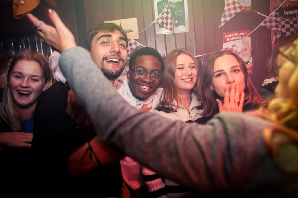 Groep vrienden die samen op de foto gaat in de kroeg